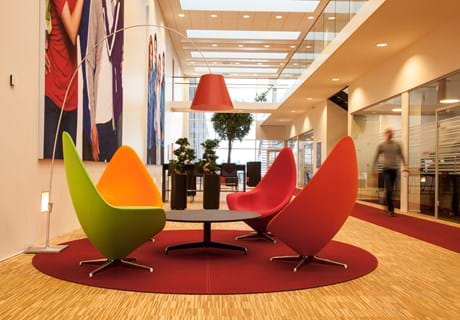 Runde, røde filttæpper i lounge område